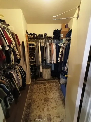 a view of walk in closet with clothes and shoes