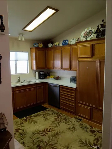 a kitchen with granite countertop a refrigerator and cabinets