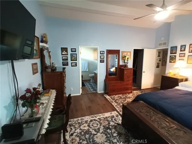 a bedroom with a bed and dresser with mirror