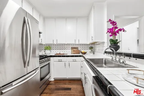 a kitchen with granite countertop a sink stainless steel appliances and cabinets