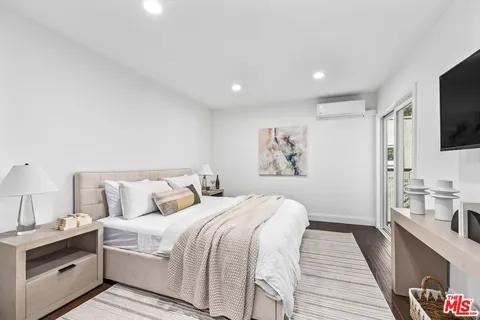 a spacious bedroom with a bed and a flat screen tv