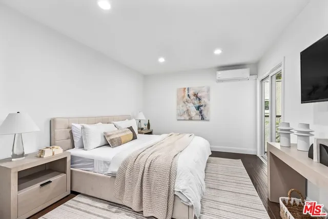 a spacious bedroom with a bed and a flat screen tv