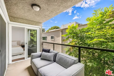 a balcony with furniture and a potted plant