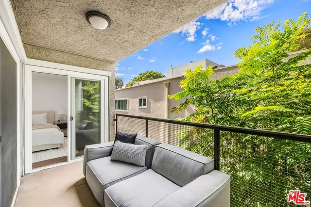 a balcony with furniture and a potted plant