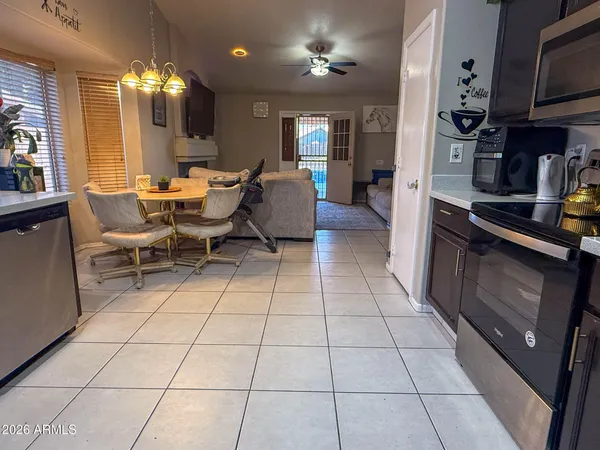 a kitchen with stainless steel appliances kitchen island granite countertop a rug a stove a microwave and a dining table