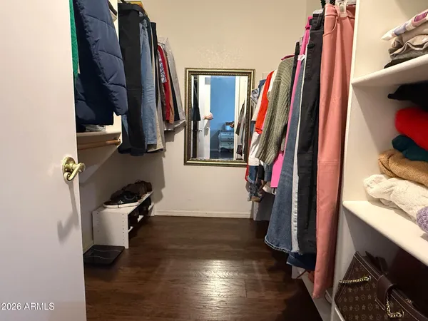 a view of walk in closet with clothes and shoes