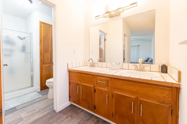 a bathroom with a granite countertop sink toilet and shower