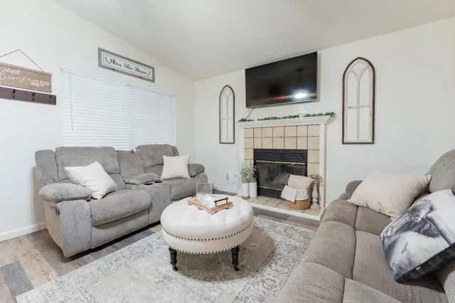 a living room with furniture a fireplace and flat screen tv