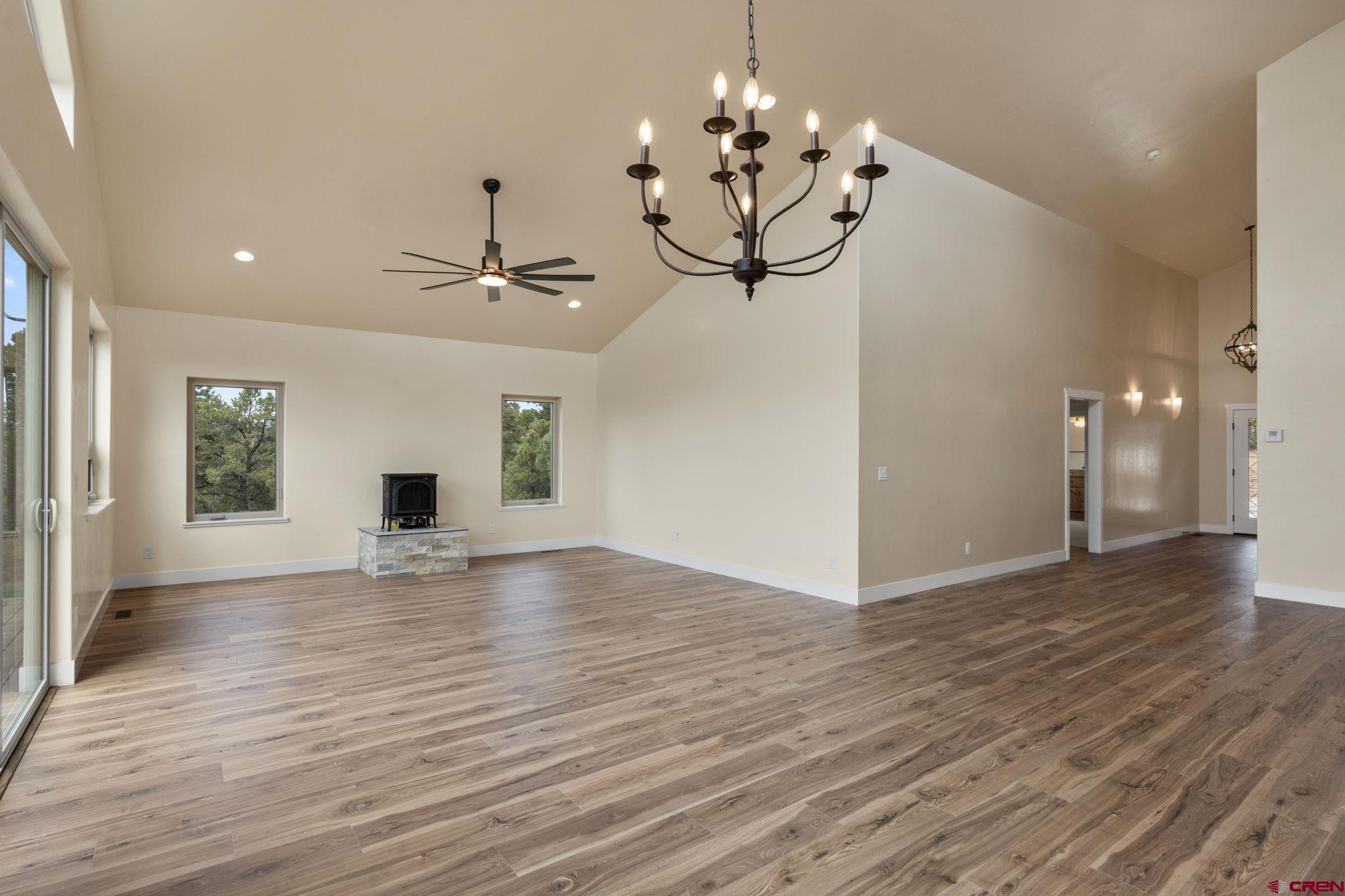 640 Sawmill Road Durango, CO 81303 - Photo 11 of 42 an empty room with wooden floor chandelier and windows