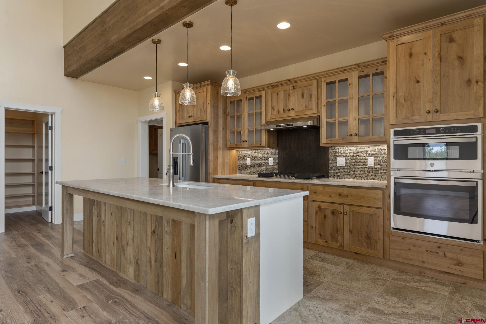 640 Sawmill Road Durango, CO 81303 - Photo 14 of 42 a kitchen with stainless steel appliances granite countertop a stove a sink and a refrigerator