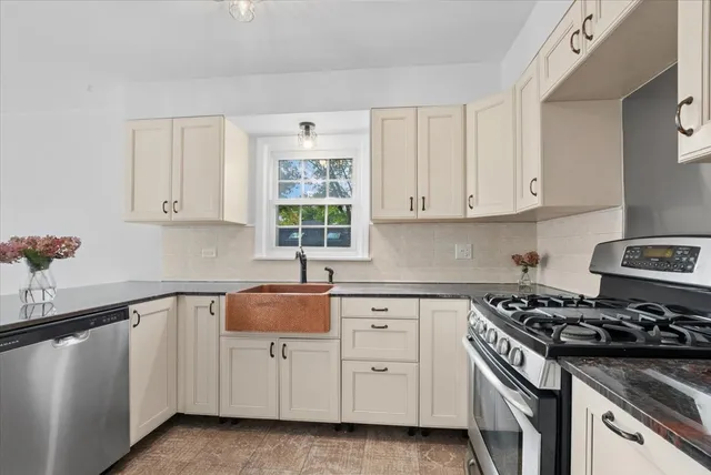 a kitchen with white cabinets and appliances