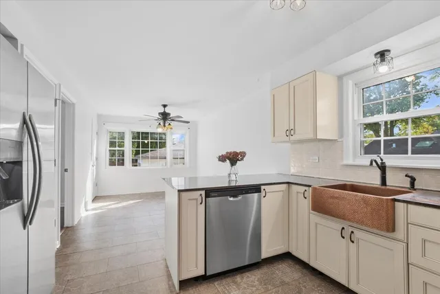 a kitchen with white cabinets and sink