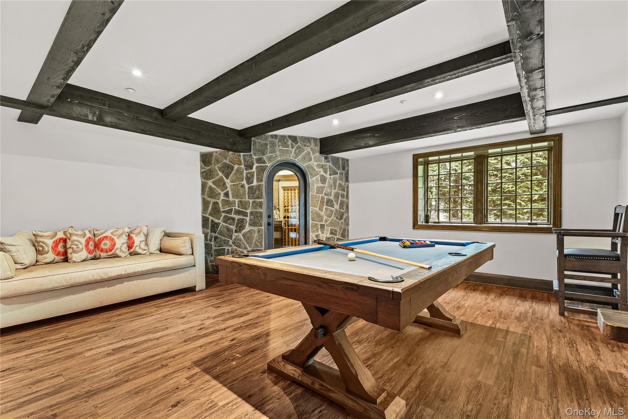 19 Park Drive South Rye, NY 10580 - Photo 36 of 42 Sophisticated timber beams and a custom stonework accent wall frame a private, temperature-controlled wine cellar. This refined billiards lounge offers a premier setting for high-end entertaining and leisure.