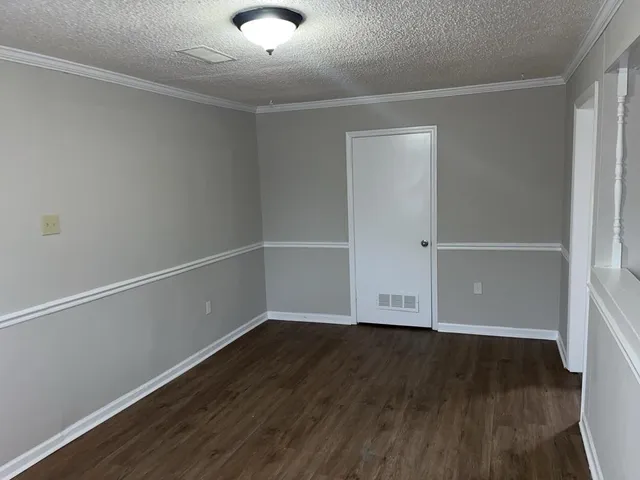 an empty room with wooden floor and white walls