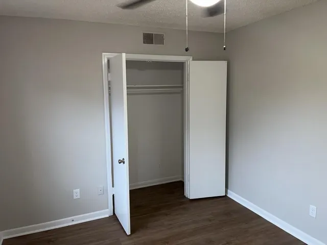 an empty room with wooden floor and closet