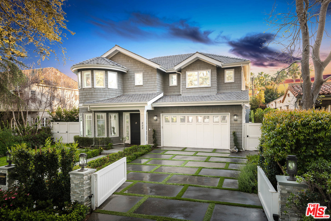 a front view of house with yard and trees around