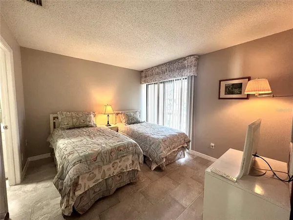 a bedroom with a large bed and a flat tv screen on dresser
