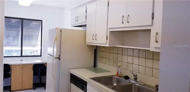 a kitchen with a stove and white cabinets