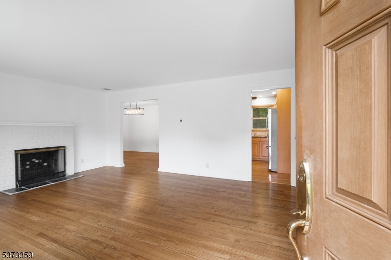 1 Baldwin Road Florham Park, NJ 07932 - Photo 3 of 33 a view of an empty room with wooden floor and a fireplace