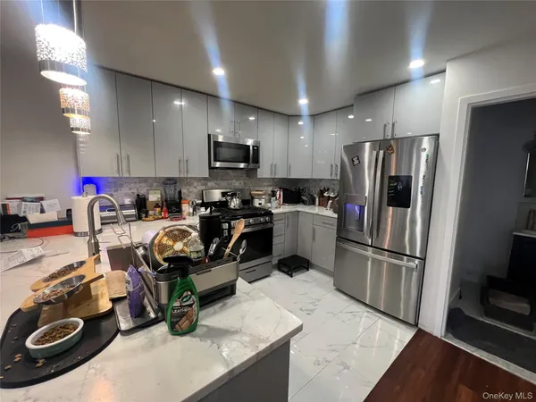 a kitchen with kitchen island granite countertop a refrigerator stove and sink