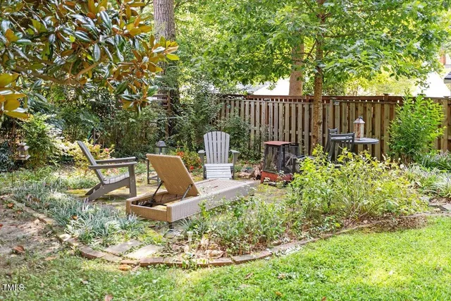 a view of a chair and table in backyard of the house