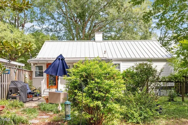 a view of a backyard with plants and tree