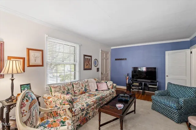 a living room with furniture a flat screen tv and a window