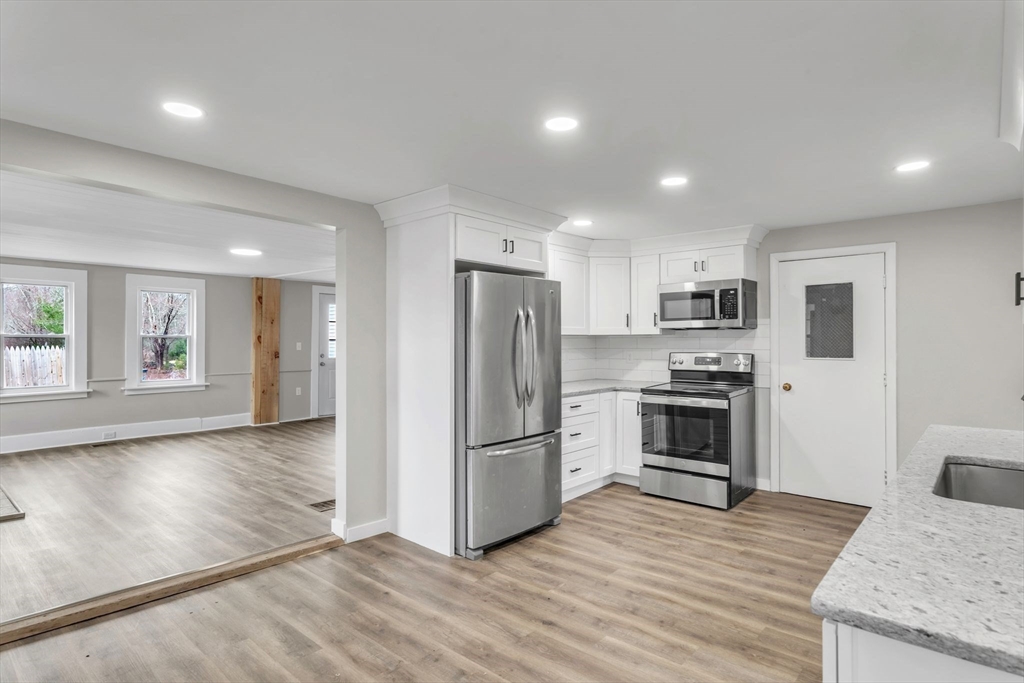 140 Greenwich Plains Road Ware, MA 01082 - Photo 11 of 42 a kitchen with granite countertop a refrigerator and a stove top oven