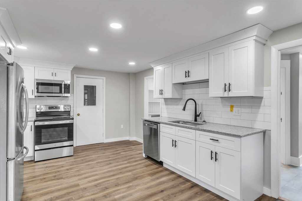 140 Greenwich Plains Road Ware, MA 01082 - Photo 10 of 42 a kitchen with stainless steel appliances granite countertop a kitchen island hardwood floor sink and stove