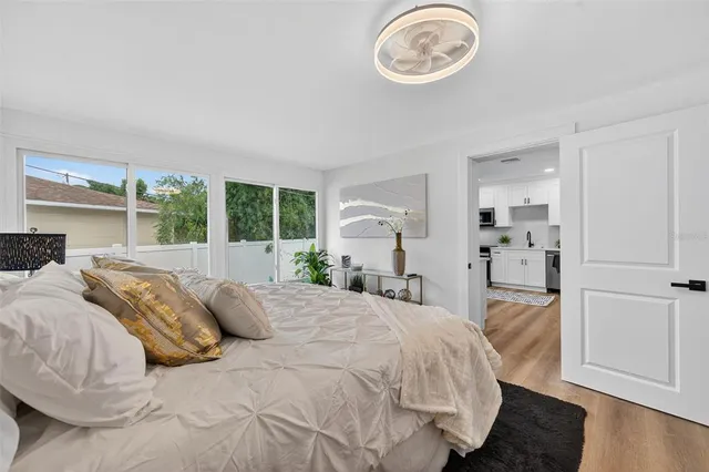 a view of empty room with wooden floor and ceiling fan