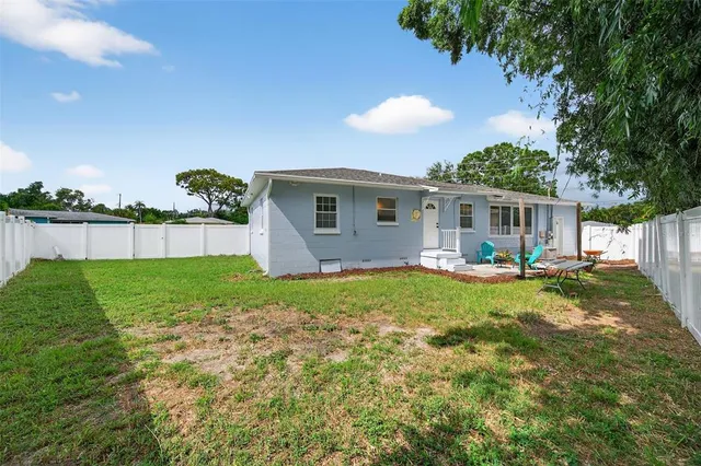 an aerial view of residential houses with outdoor space and trees