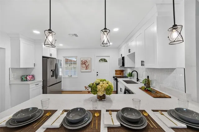 a kitchen with stainless steel appliances granite countertop a refrigerator and a stove top oven