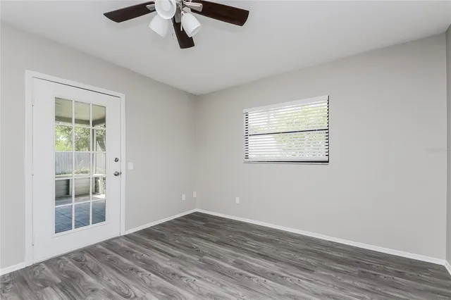 a view of empty room with wooden floor and fan
