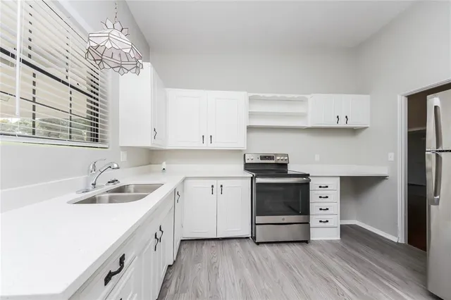 a kitchen with stainless steel appliances a stove a sink and cabinets