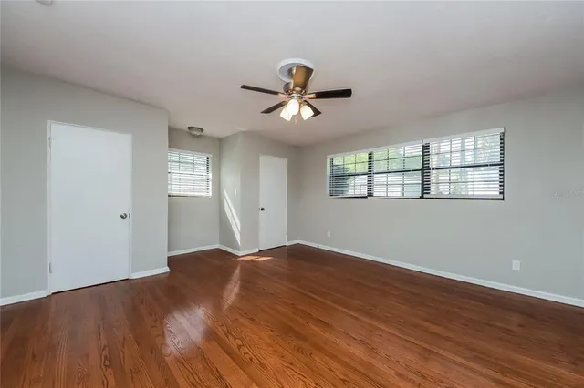 a view of a room with wooden floor and a ceiling fan