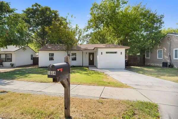 a front view of house with yard and trees in the background