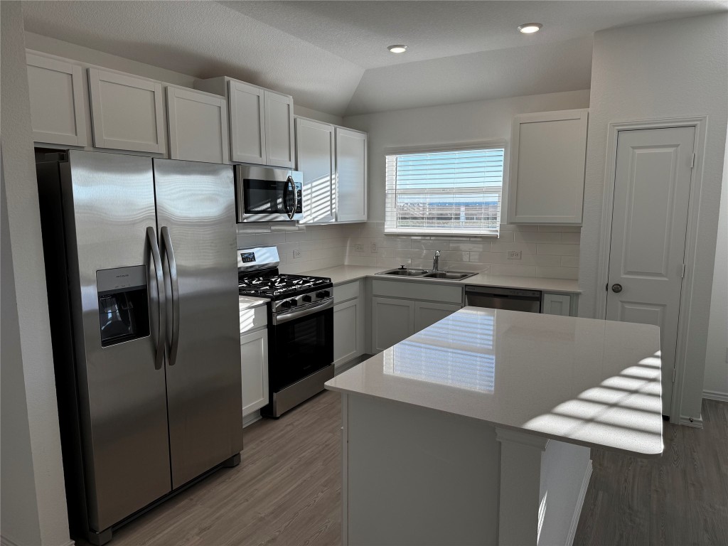 515 Avre Loop Kyle, TX 78640 - Photo 2 of 4 a kitchen with stainless steel appliances kitchen island granite countertop a refrigerator a sink a stove a microwave and island