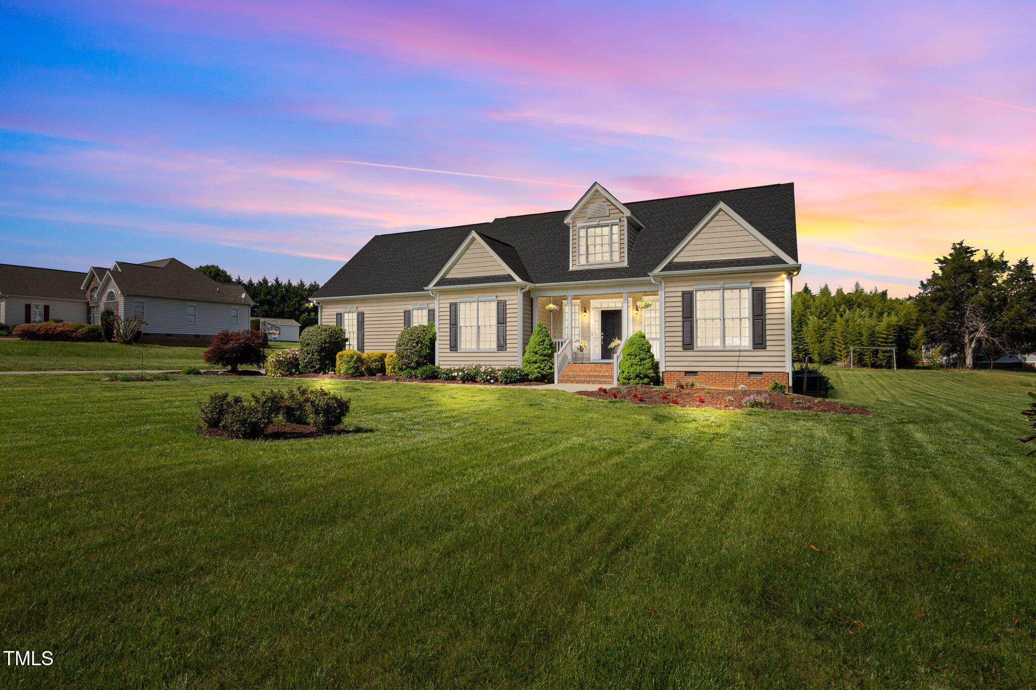 a front view of a house with a garden and plants