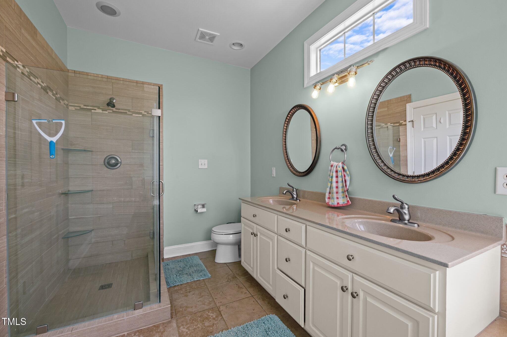 281 Derwin Drive Timberlake, NC 27583 - Photo 15 of 29 a bathroom with a double vanity sink mirror and a toilet