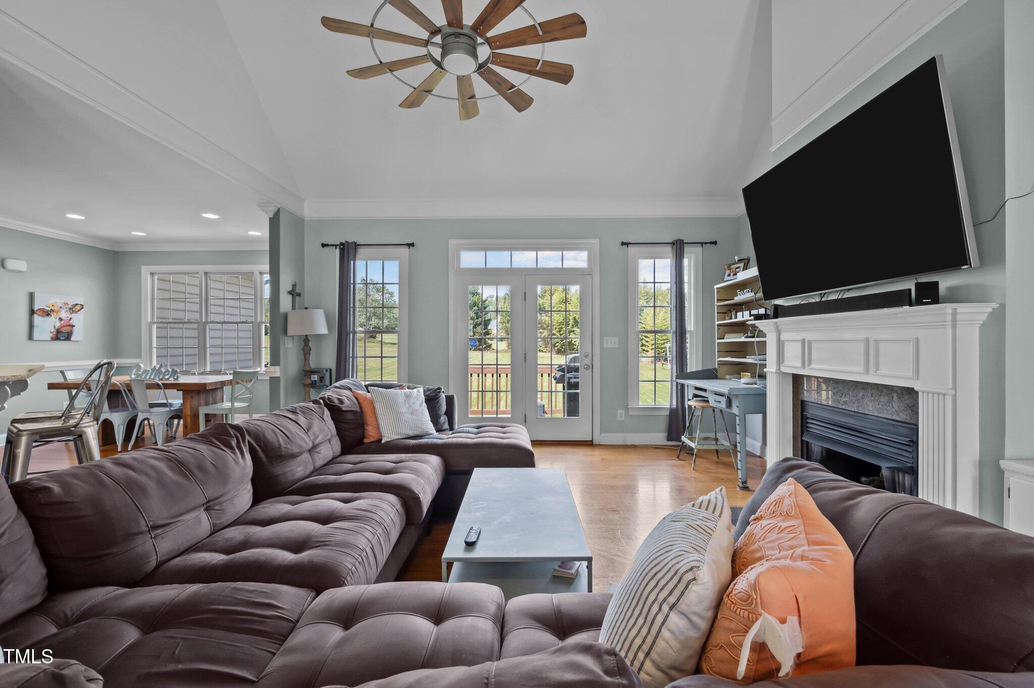 281 Derwin Drive Timberlake, NC 27583 - Photo 4 of 29 a living room with furniture a flat screen tv and a fireplace