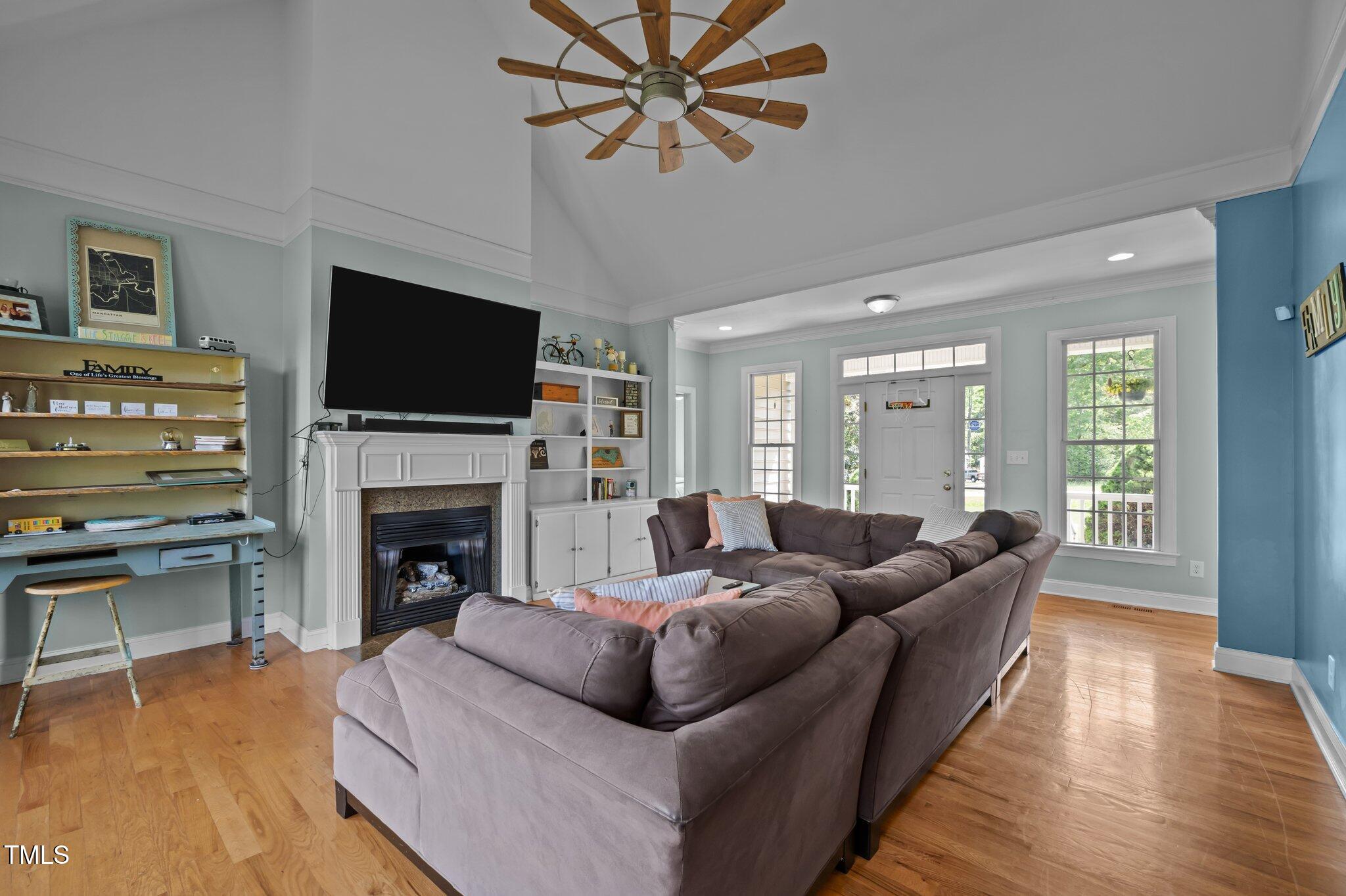 281 Derwin Drive Timberlake, NC 27583 - Photo 5 of 29 a living room with furniture a fireplace and a flat screen tv