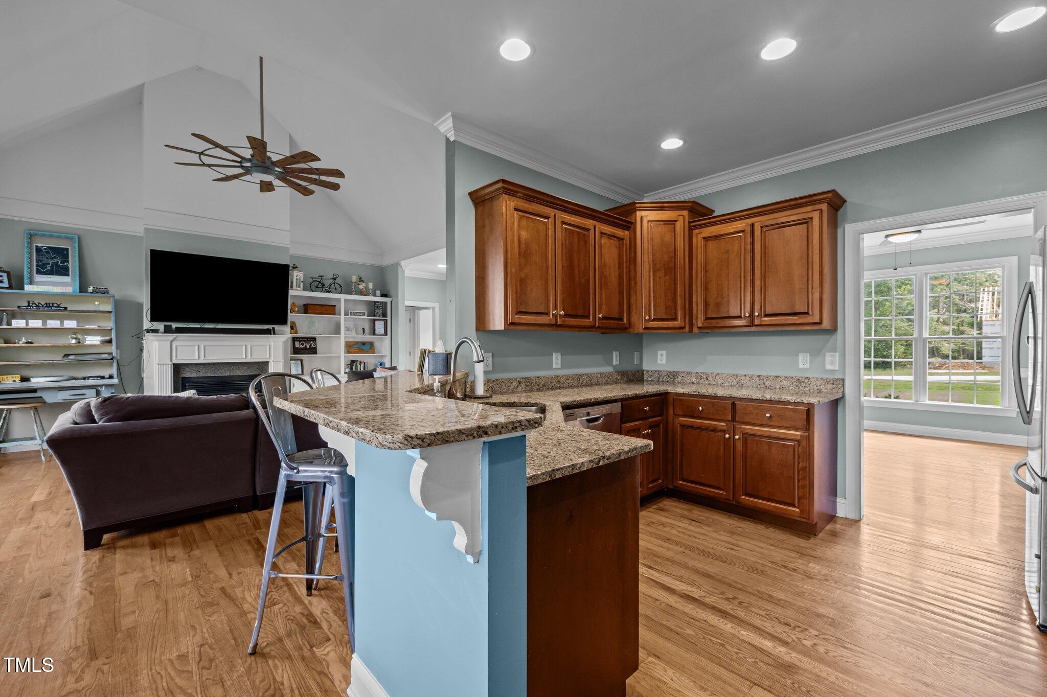 281 Derwin Drive Timberlake, NC 27583 - Photo 7 of 29 a kitchen with stainless steel appliances granite countertop a stove top oven a sink dishwasher a dining table and chairs with wooden floor