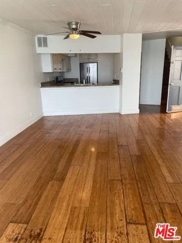 a kitchen with kitchen island a sink and wooden floor