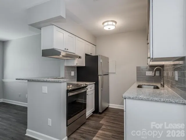 a kitchen with granite countertop white cabinets and a sink