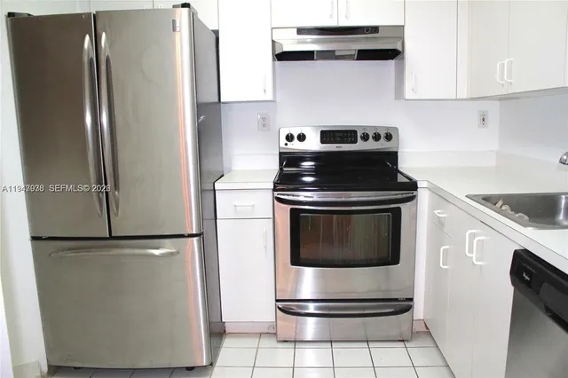 a kitchen with cabinets and stainless steel appliances