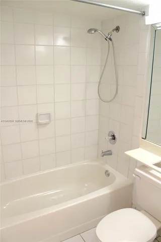 a bathroom with a bath tub a toilet and a shower