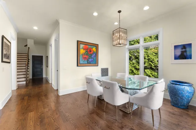 a dining room with furniture a chandelier and wooden floor