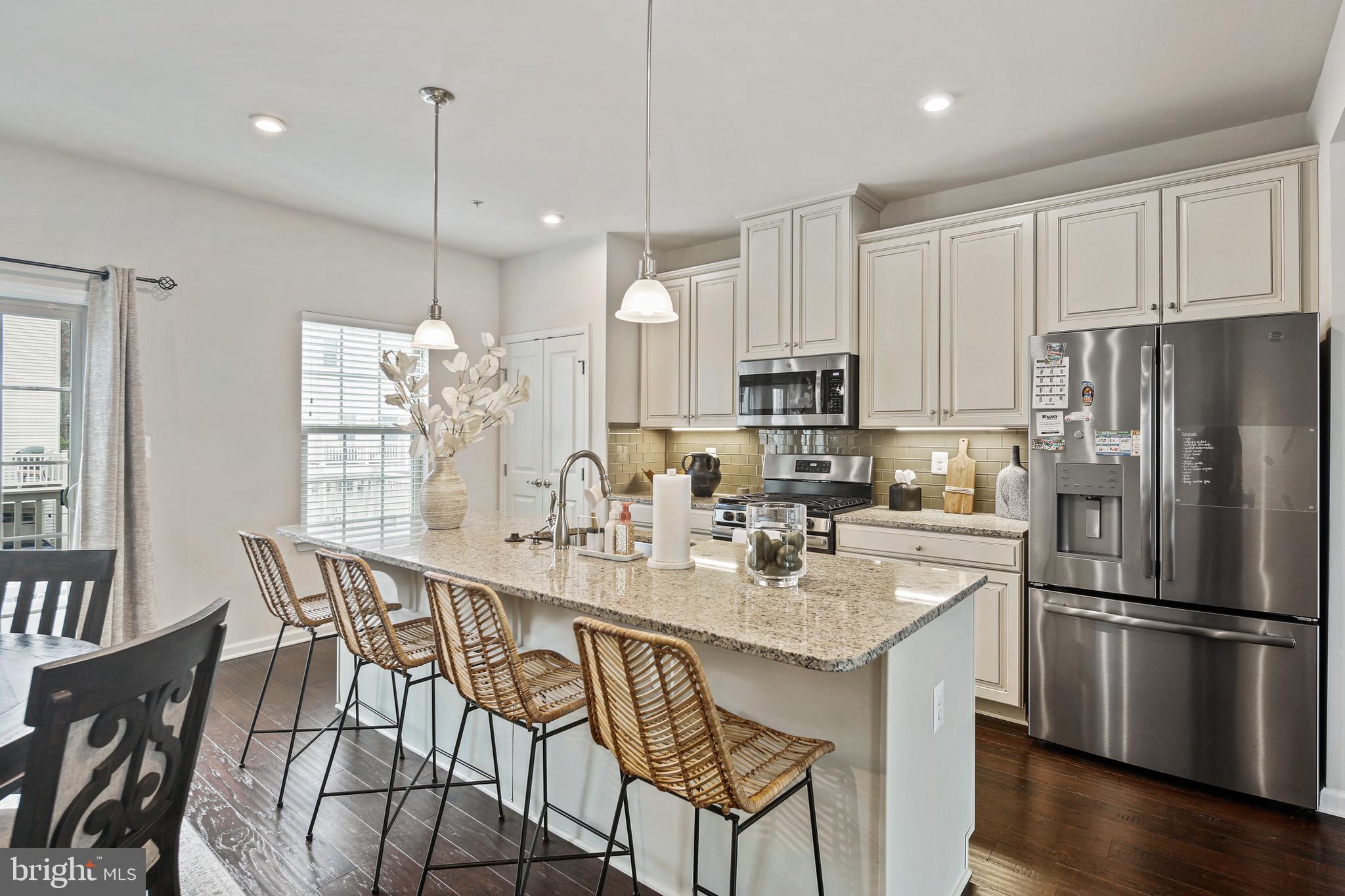 10012 Sandy Run Road Baltimore, MD 21220 - Photo 18 of 34 a kitchen with stainless steel appliances granite countertop a refrigerator a sink dishwasher a dining table and chairs with wooden floor