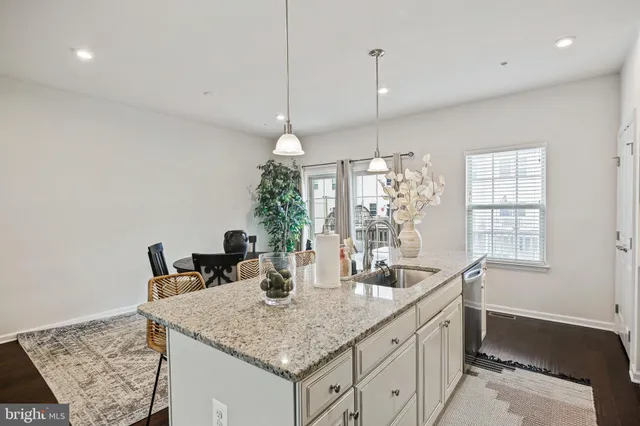 a kitchen with granite countertop a sink a center island and windows
