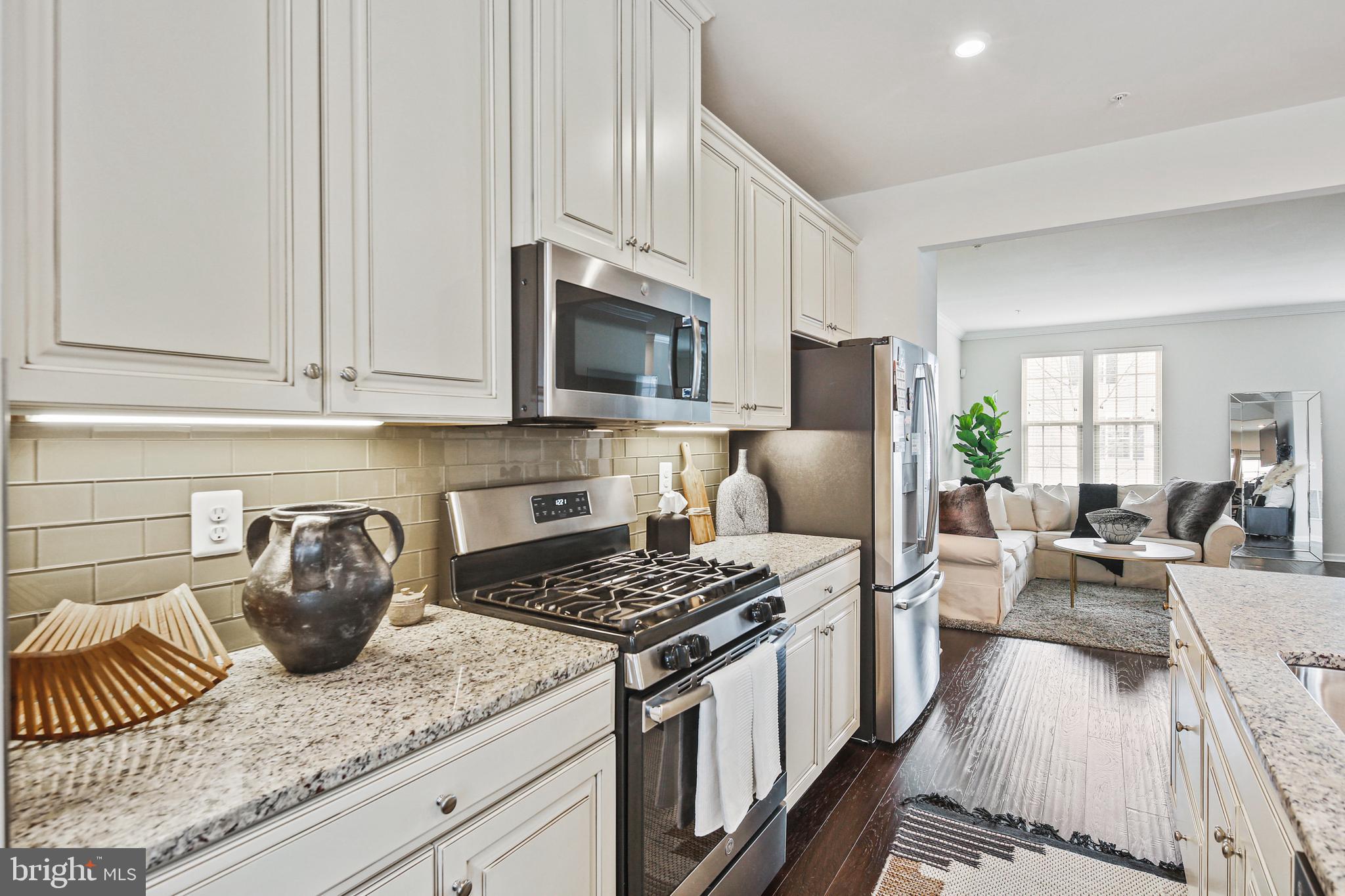 10012 Sandy Run Road Baltimore, MD 21220 - Photo 20 of 34 a kitchen with stainless steel appliances granite countertop a stove a sink dishwasher a refrigerator a stove and oven with wooden floor